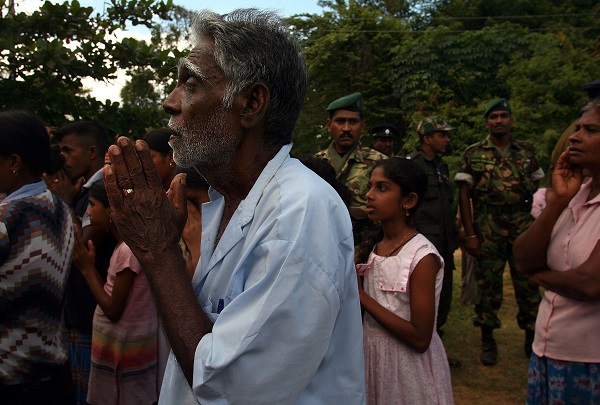 A man prays at a camp for the internally displaced due to fighting December 10, 2006 near the government controlled town of Kantalai in northeastern Sri Lanka. Some 5,000 Sinalese fled their villages in the past two days due to artillery attacks from the rebel Liberation Tamil Tigers of Eelam, (LTTE). 