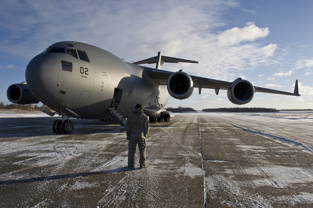 U.S. Air Force Tech. Sgt. Joseph Johns, a C-17 Globemaster III crew chief with the Heavy Airlift Squadron at Papa Air Base, Hungary, communicates with the C-17 pilots while on an airfield in Lithuania, Dec. 10, 2010. The aircraft was on the last leg of a three-day mission that would span over 7000 miles covering the countries of Hungary, Poland, Afghanistan and Lithuania as they move more than 75,000 tons of cargo. 