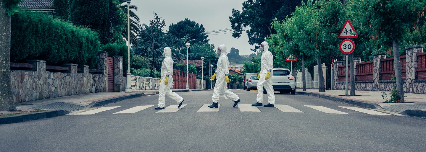 People in bacteriological protection suits walking down an empty street