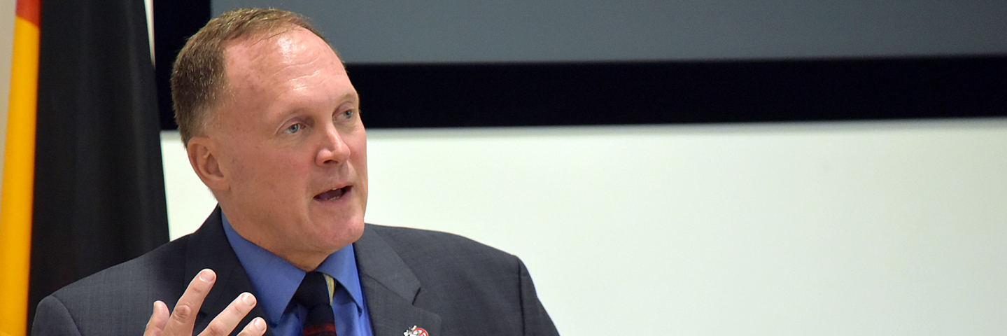 A photograph of James Howcroft speaking at a George C. Marshall event.