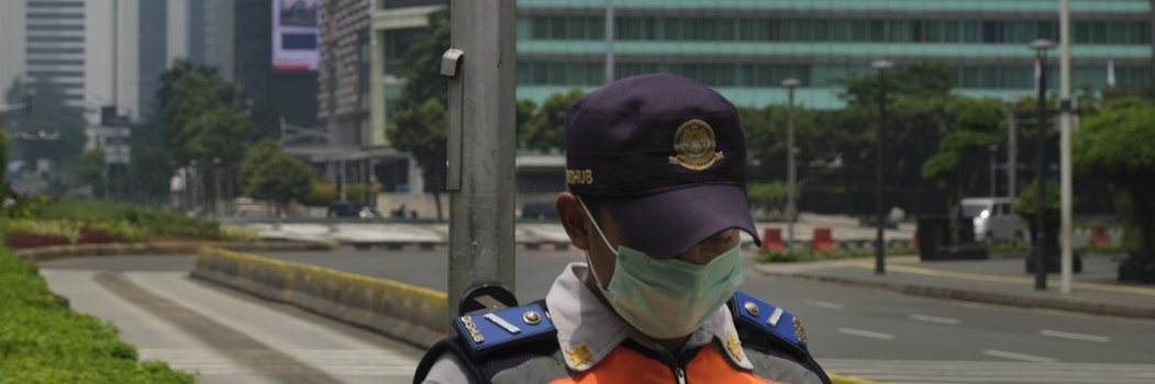 A policeman stands guard underneath The Welcome Monument in Jakartas nearly empty business district on March 30, 2020 in Jakarta, Indonesia.