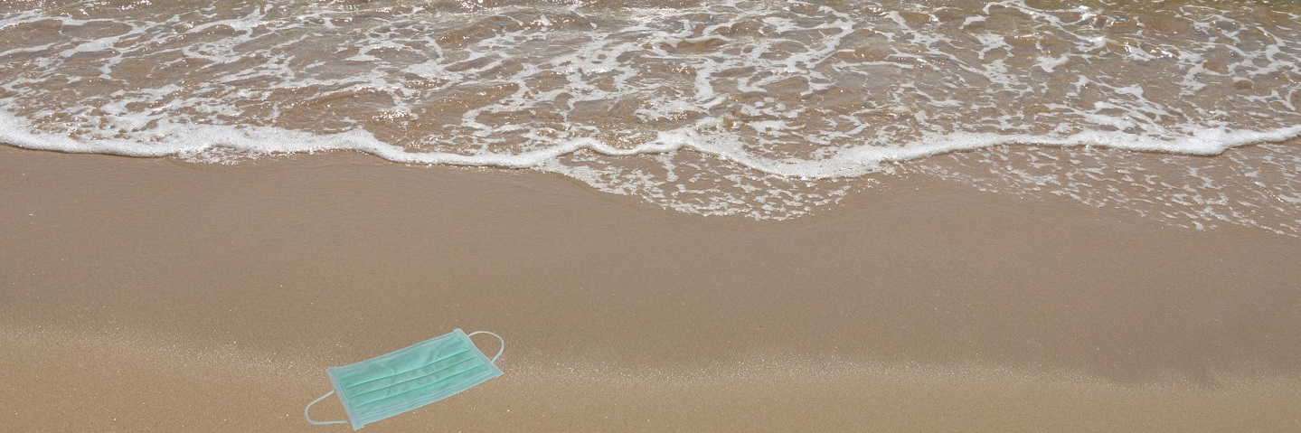 Hygienic mask for protection nose and mouth trash on beach in a sunny day.