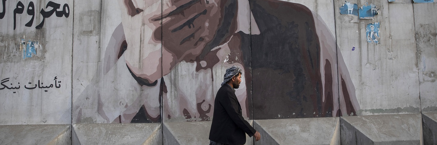 A man walks by a mural painted on a blast wall on September 29, 2019 in Kabul, Afghanistan.