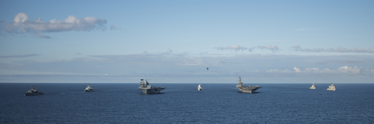 A photograph of the Royal Navy frigates HMS Iron Duke (F234), left, and HMS Westminster (F237), the Royal Norwegian Navy frigate KNM Helge Ingstad (F313), the Royal Navy aircraft carrier HMS Queen Elizabeth (R08), the U.S. Navy guided-missile destroyer USS Donald Cook (DDG-75), the aircraft carrier USS George H.W. Bush (CVN-77), and the guided-missile cruiser USS Philippine Sea (CG-58) underway in formation during exercise "Saxon Warrior 2017", 8 August 2017.