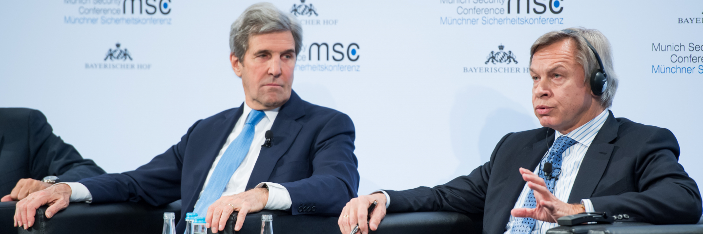 A photograph of John F. Kerry and Aleksey Pushkov at the Munich Security Conference in 2018.