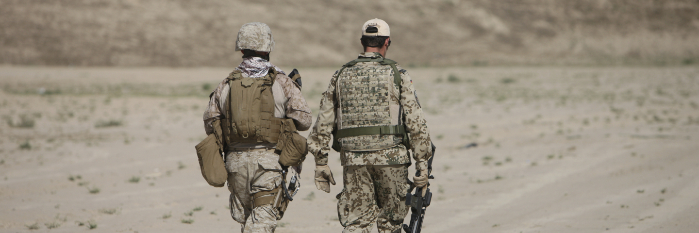 U.S. Marine and German Coalition soldier walk in a wadi near Kunduz, Afghanistan.