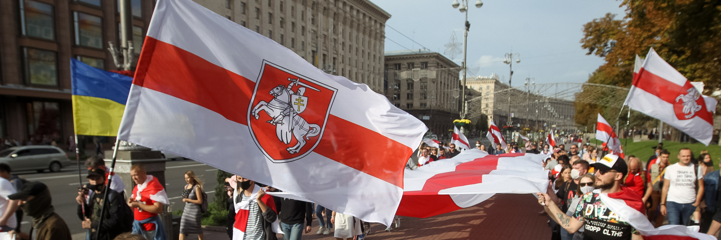 People hold the historical white-red-white flags of Belarus during a rally of solidarity with Belarusian protests in Kyiv, Ukraine on 04 October 2020.