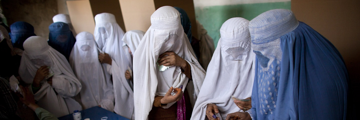 Afghan women in burqas vote at a polling station