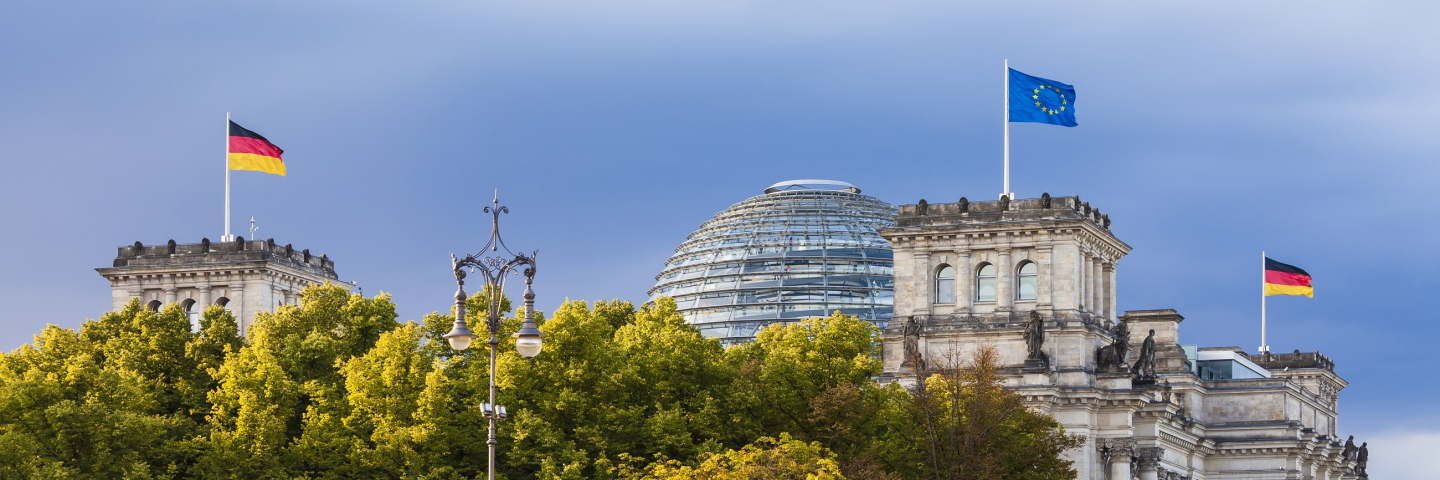 Germany, Berlin, Berlin-Tiergarten, Reichstag building with flags of EU and Germany.