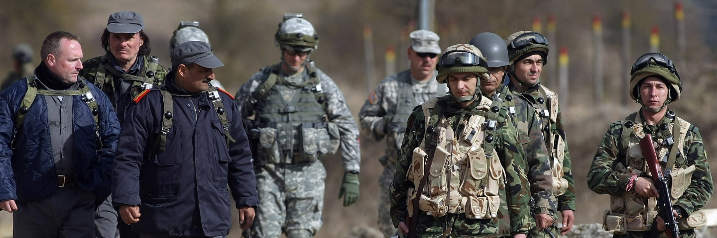 U.S. troops of the 173rd Airborne Brigade based in Vicenza, Italy, along with Bosnian (L) and Bulgarian (R) soldiers meet with actors playing Afghan village leaders during training exercises
