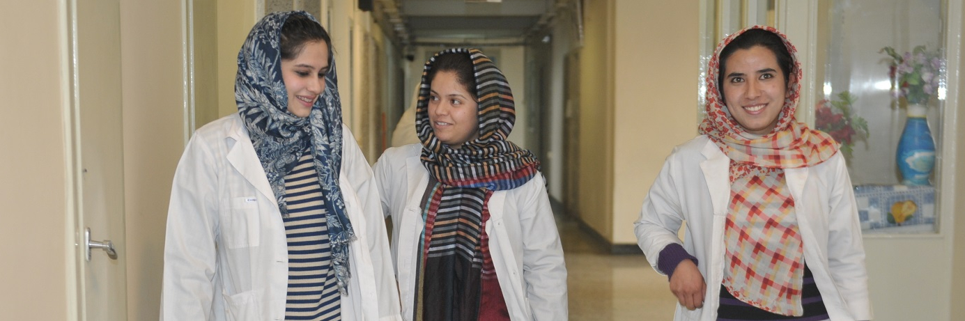 Two female medical interns and a doctor walk the corridors of Kabul National Military Hospital.