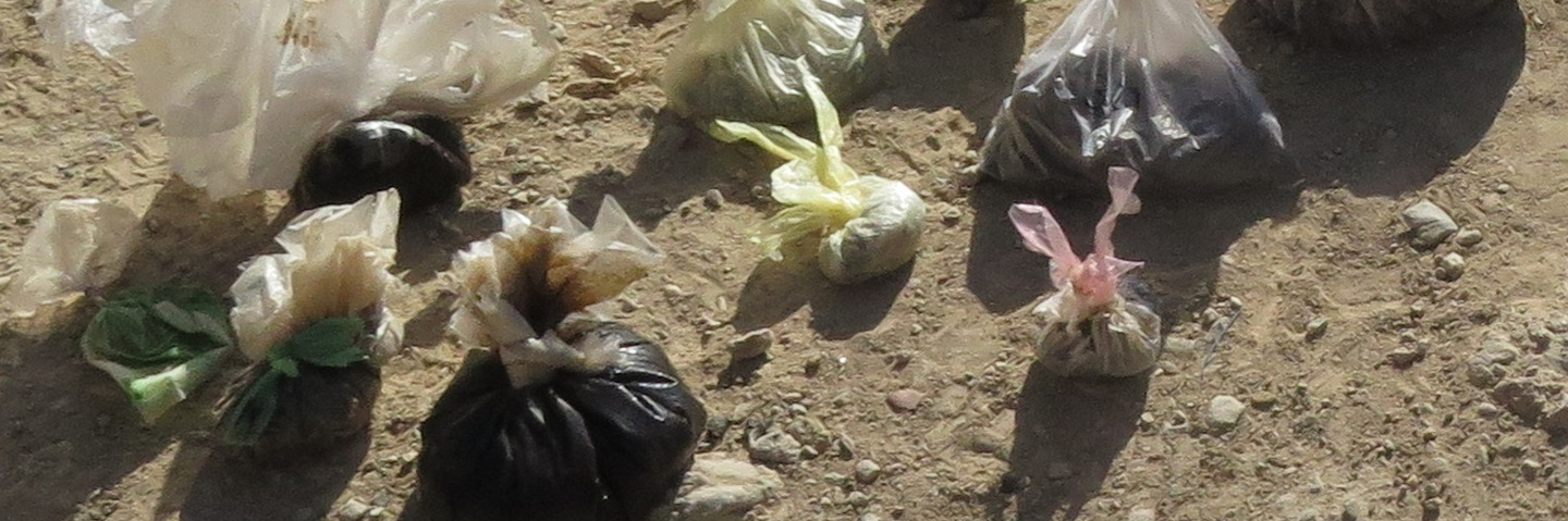 Taliban-packaged narcotics, laying in bags on the ground, seized by Afghan Special Security Forces.