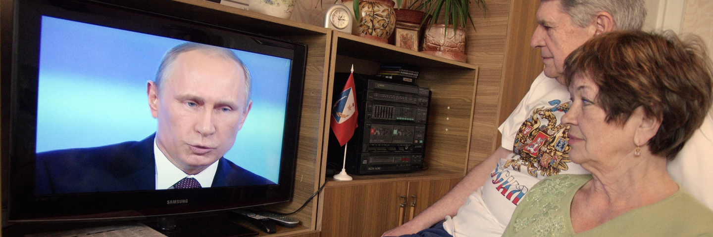 A couple watches the TV broadcast of Russian President Vladimir Putin's annual televised question-and-answer session with the nation in the Crimean port of Sevastopol, on April 17, 2014.