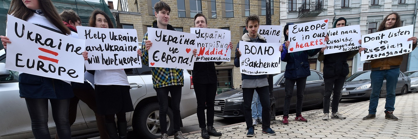 Young Ukrainian activists hold placards reading "Help Ukraine and Ukraine will help Europe", "Ukraine=Europe", "Europe is in our hearts" and "Don't listen Russian propaganda!"