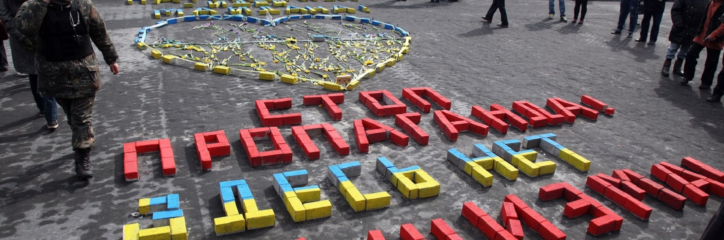 People look at letters left on the ground reading "Stop propaganda ! There is no fascism here" at Independence Square in Kiev.
