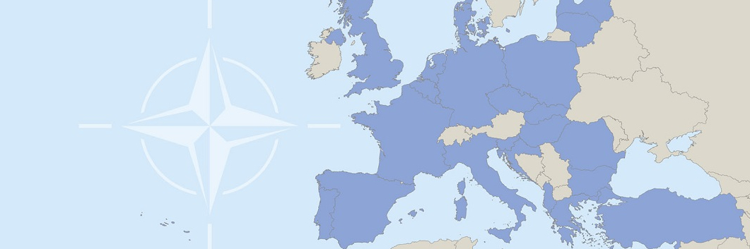 Overhead view of world map with NATO logo in the middle of the ocean.