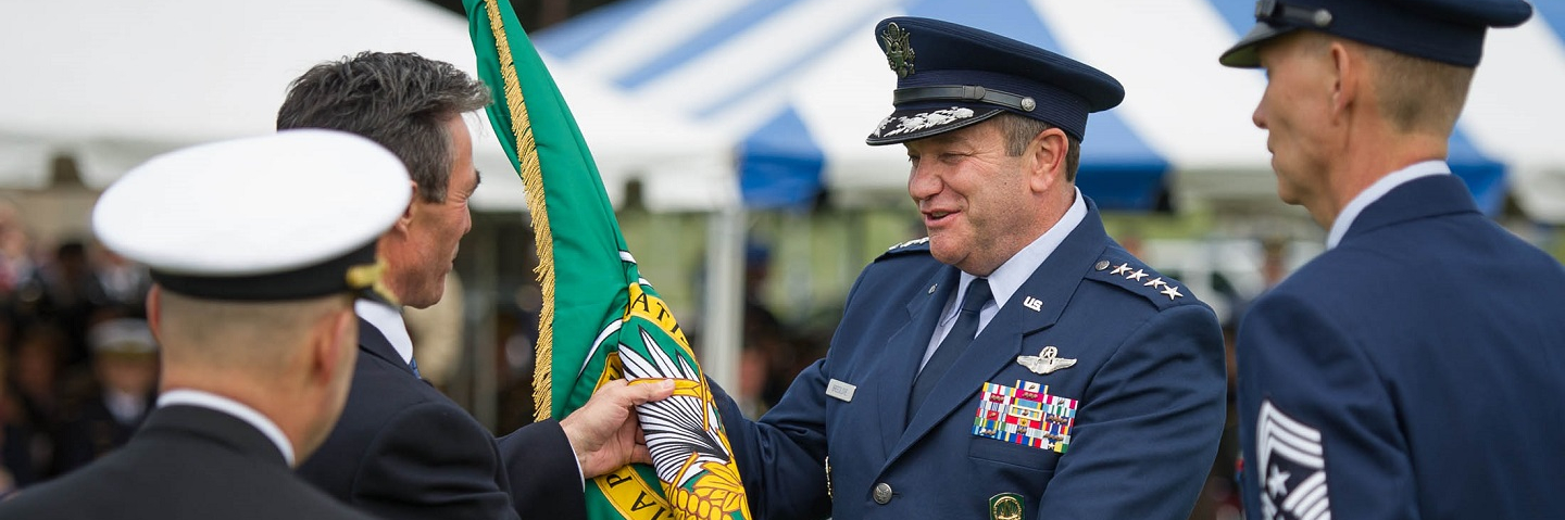 Incoming Supreme Allied Commander, Europe, General Philip Breedlove, receives the SHAPE Command Flag from NATO Secretary General Anders Fogh Rasmussen at the change of command ceremony for NATO's Supreme Allied Commander Europe.
