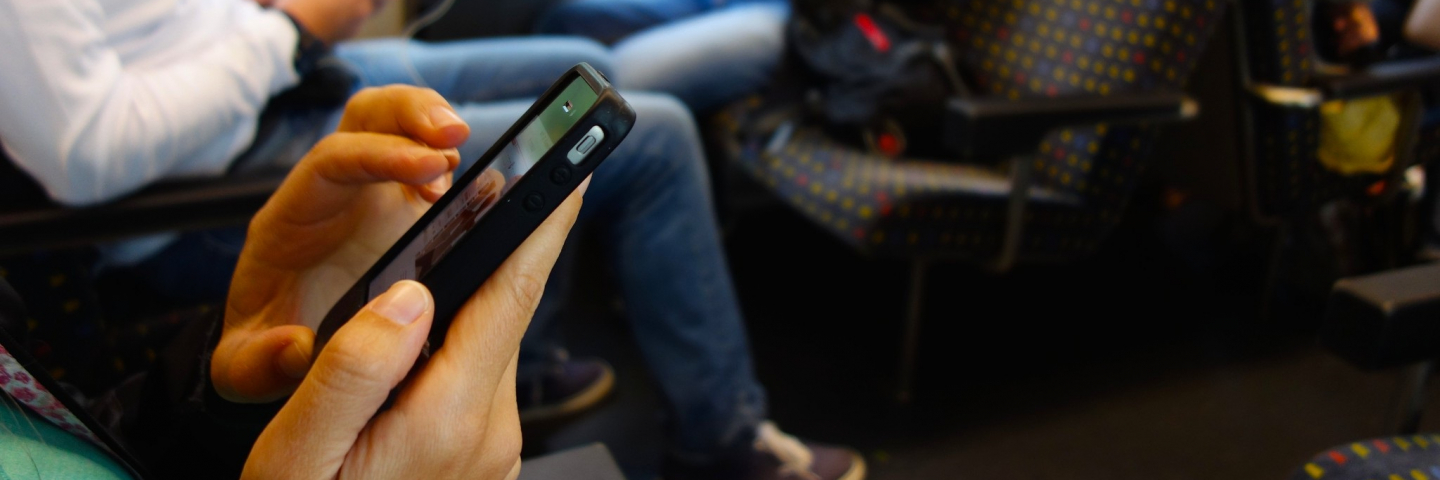 People on a train using their smartphones.