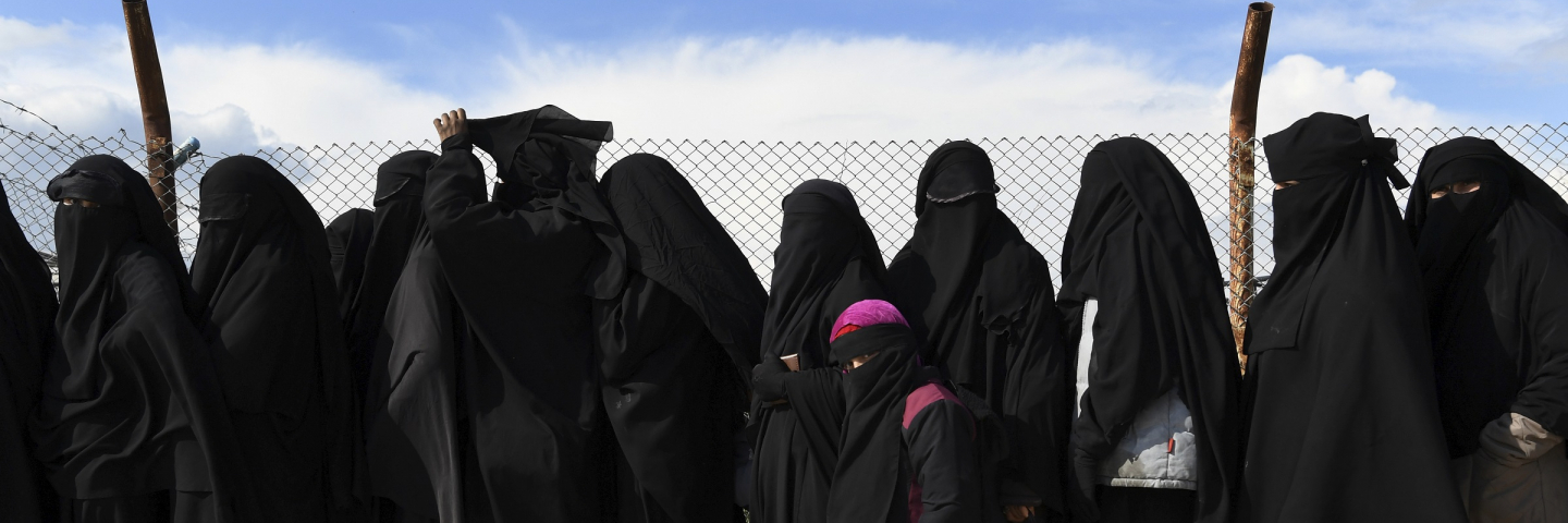 Wives and childern of former ISIS fighters line up in the foreign section of the al-Hawl refugee camp