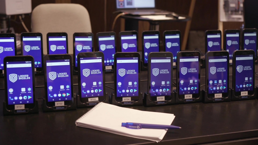 Photo of 20 cellular phones lined up to be used for Exercise Locked Shields 2019.