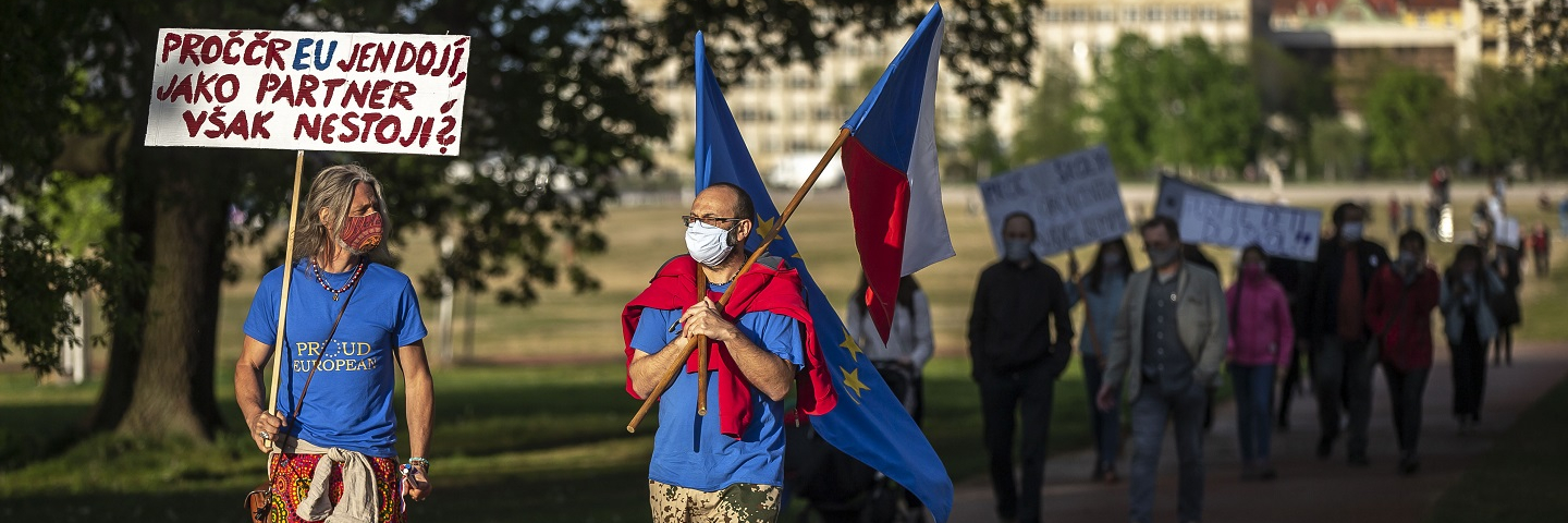 People walk holding signs as they attend a rally to protest what they say is a chaotic response of the government to the coronavirus pandemic on April 29, 2020 in Prague, Czech Republic. 