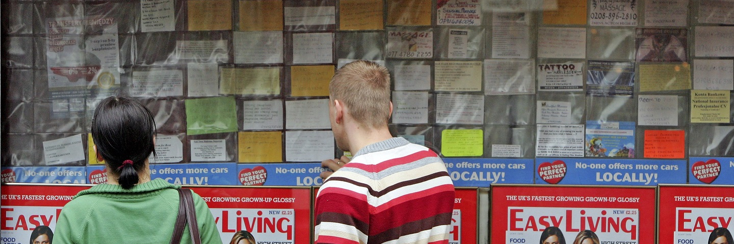 Polish people look at a job message board outside a shop in an area popular with Polish people on May 15, 2006 in west London, England.