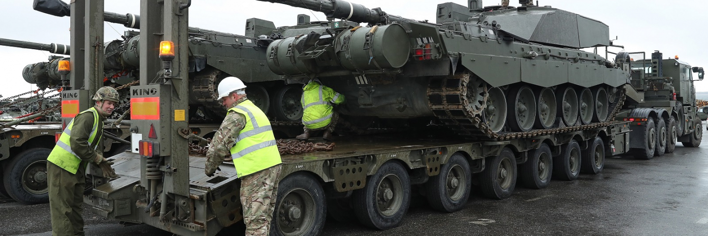 A crew secures a British Army Challenger 2 tank to a truck trailer after the tank and other heavy vehicles arrived by ship on March 22, 2017 to Paldiski, Estonia.