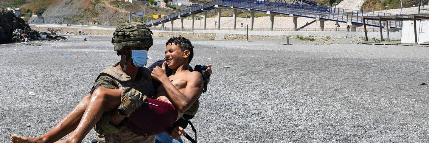 A Spanish army soldier helps a young migrant from Morocco on his arrival in Ceuta.