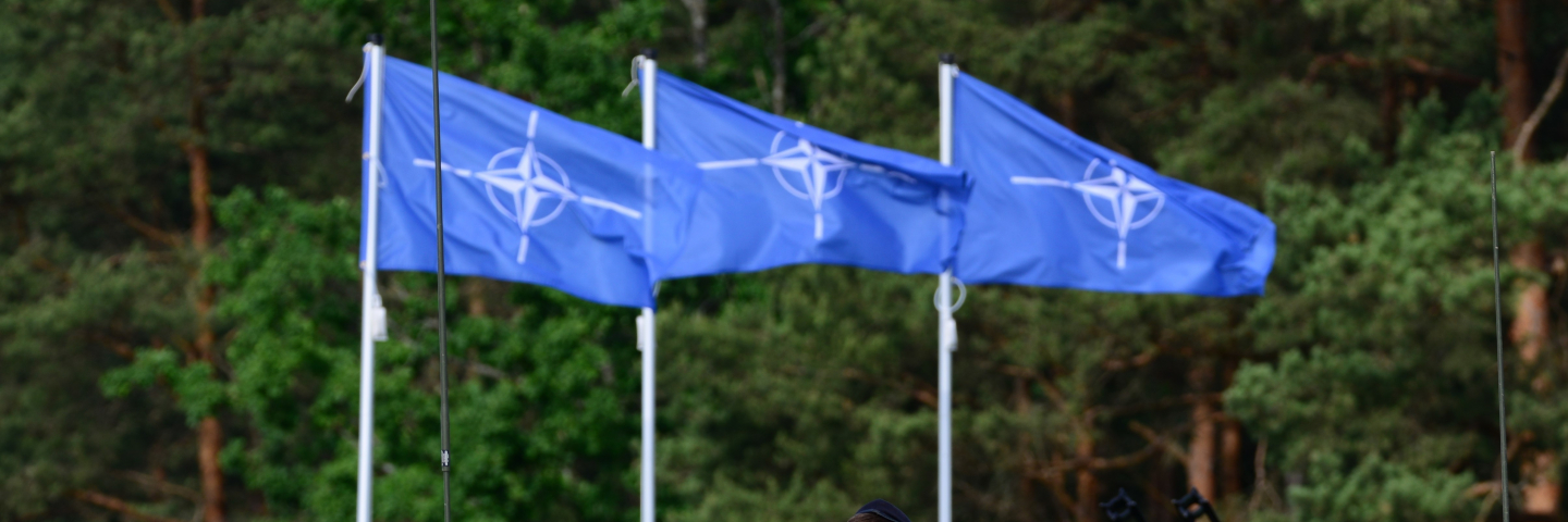 Three NATO flags blowing in the wind.