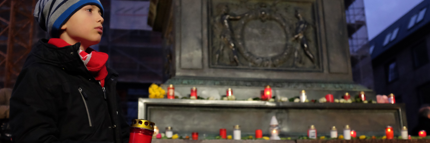A child holds a candle during a vigil near the Midnight shisha bar, one of the sites of the previous night's shootings, on February 20, 2020 in Hanau, Germany.