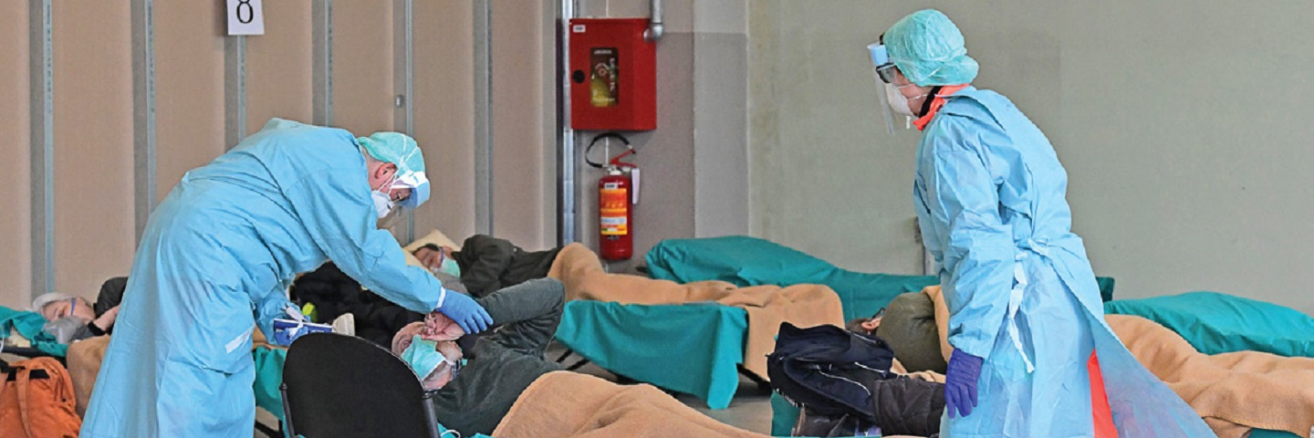 Hospital employees at the Brescia hospital in Lombardy, Italy, tend to patients at a temporary emergency structure where new arrivals presenting COVID-19 symptoms were tested in March 2020. Italy’s medical system was overloaded during the early weeks of the pandemic.