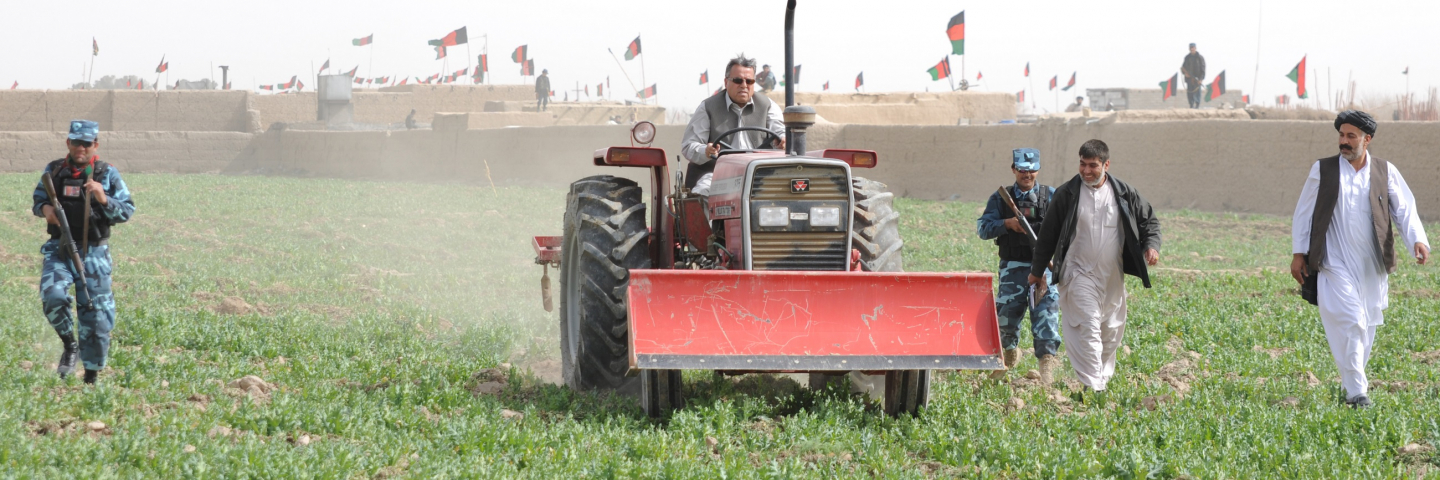 Governor Toryalai Wesa, governor of Kandahar province, drives a tractor through a poppy field in Maiwand district, Afghanistan as part of an event discussing poppy eradication in Kandahar province.