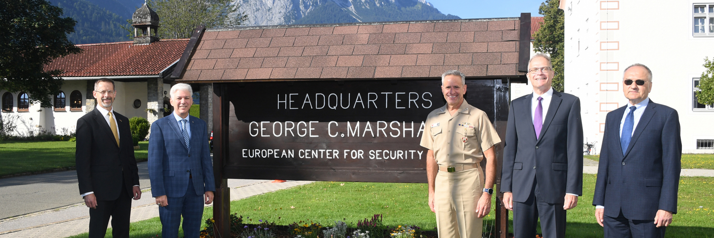 Image of Commander Burke and Marshall Center Leadership in front of sign