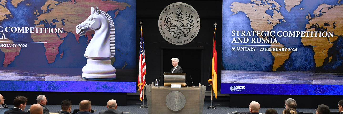 Man speaks in front of a plenary crowd.