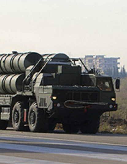 Russian military vehicles loading weapons to an airplane.