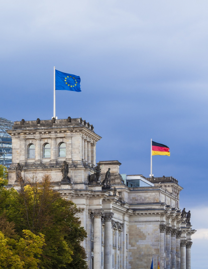 Germany, Berlin, Berlin-Tiergarten, Reichstag building with flags of EU and Germany.