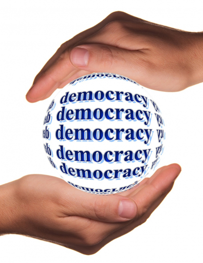 Two hands holding a ball that says Democracy