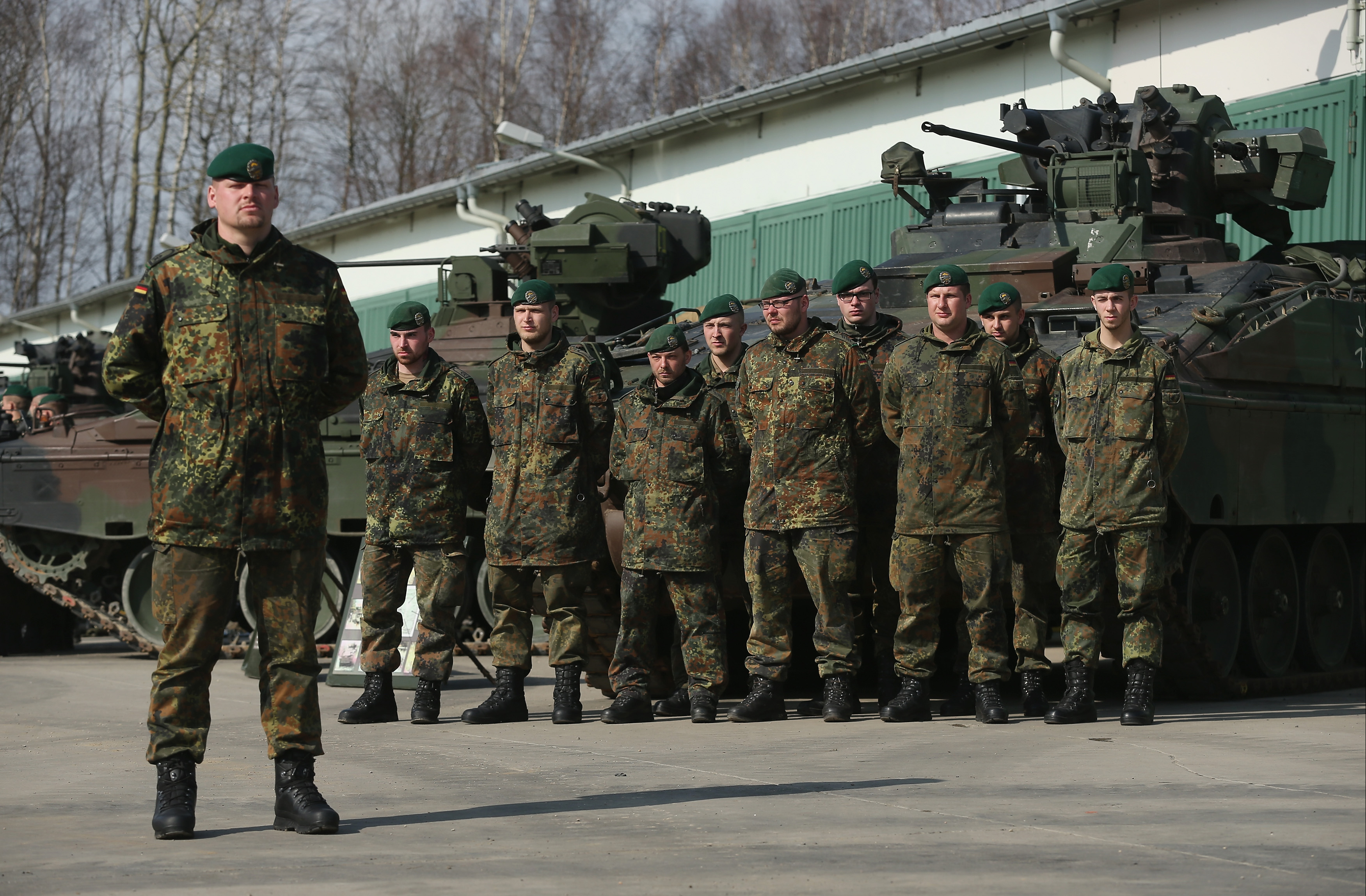 MARIENBERG, GERMANY - MARCH 10: Members of the German Bundeswehr's 371st Armoured Infantry Battalion (Panzergredanadierbataillon 371) stand to attention with Marder light tanks during a media event at the battalion's base on March 10, 2015 in Marienberg, Germany. 