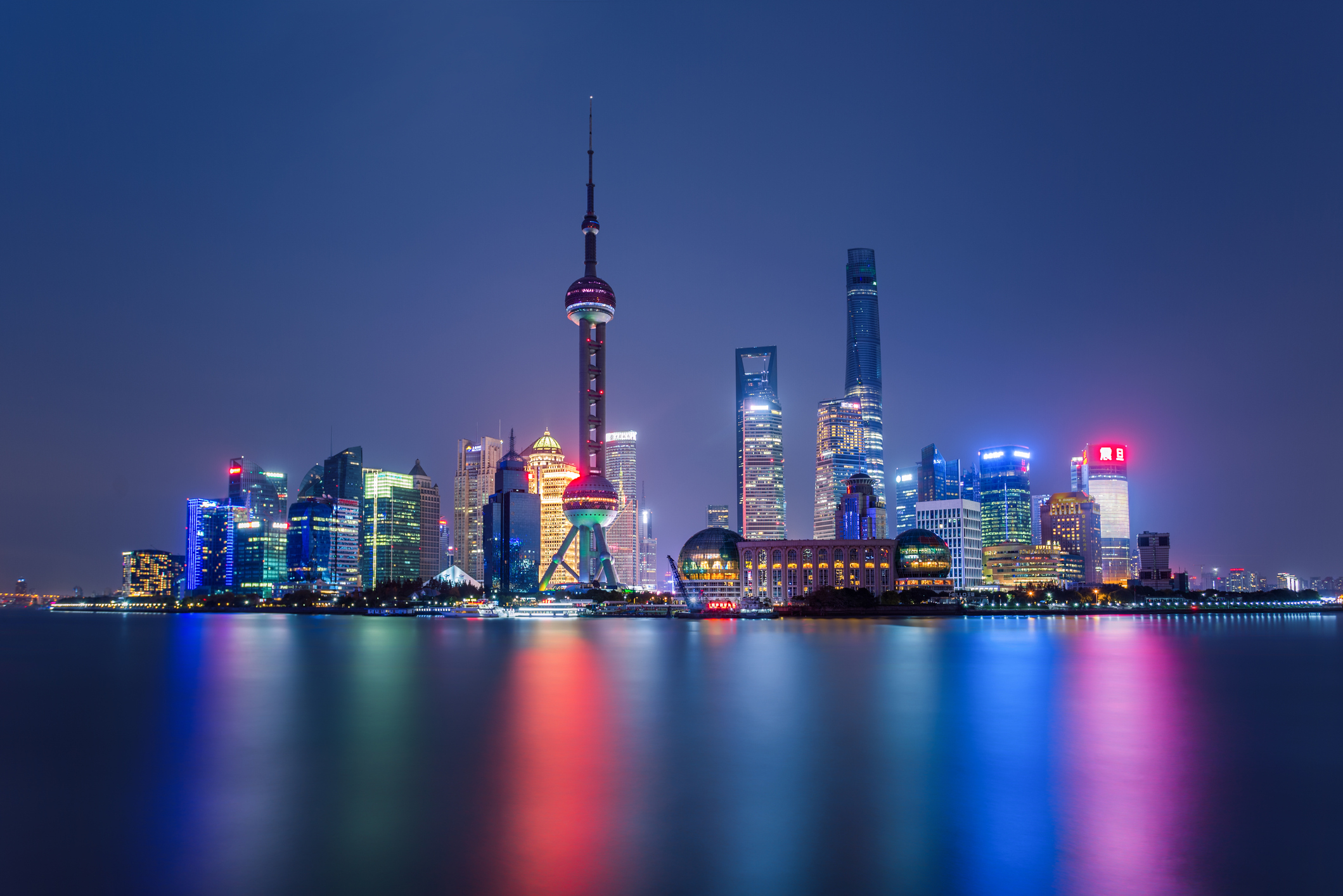 Illuminated Shanghai Skyline Reflecting On River.