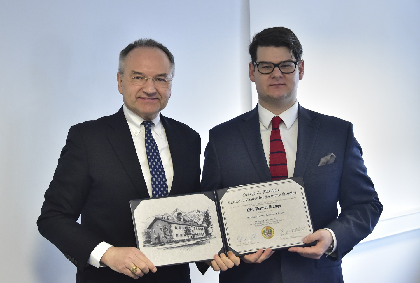 Scholar Derrick Attachie from Ghana presents a memento to Dean Andrew Michta upon completion of his presentation to the College faculty.