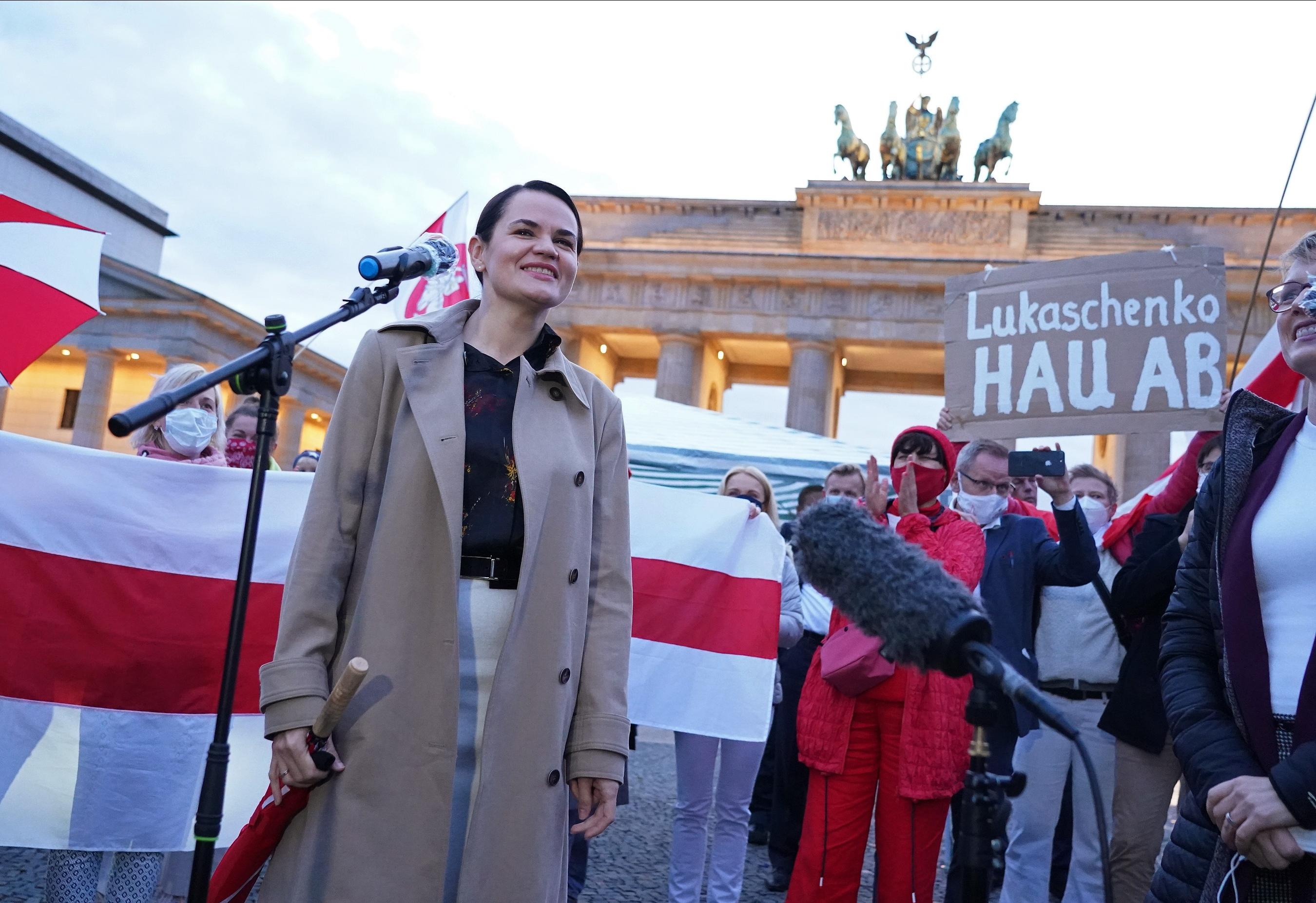 Belarusian opposition leader Svetlana Tikhanovskaya arrives to speak to supporters, including one man holding up a sign that reads: "Lukashenko go away!" in reference to Belarusian President Alexander Lukashenko, at the Brandenburg Gate on October 05, 2020 in Berlin, Germany.