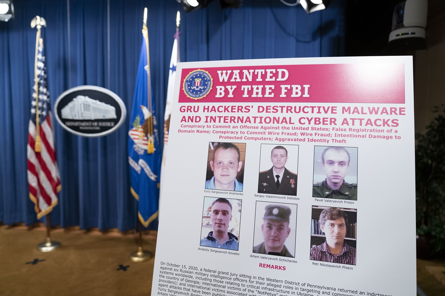  A poster showing six wanted Russian military intelligence officers is displayed before a news conference at the Department of Justice, on October 19, 2020 in Washington, DC. 