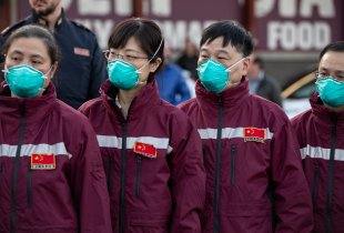 Members of a Chinese Anti-Epidemic medical expert team stand after landing at Milan - Malpensa airport on March 18, 2020 in Ferno, near Milan, Italy.