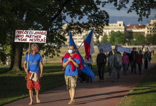 People walk holding signs as they attend a rally to protest what they say is a chaotic response of the government to the coronavirus pandemic on April 29, 2020 in Prague, Czech Republic. 