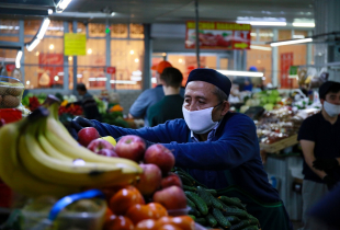 A vendor arranges fruits and vegetables at a market in Almaty on April 25, 2020, amid the coronavirus pandemic. 