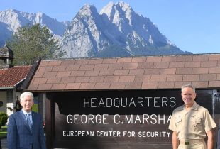 Image of Commander Burke and Marshall Center Leadership in front of sign