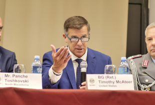 Marshall Center Deputy Director Tim McAteer speaks into a microphone during a panel at the 2024 Ohrid Regional Security Alumni Forum, the predecessor to the Western Balkans Forum.”