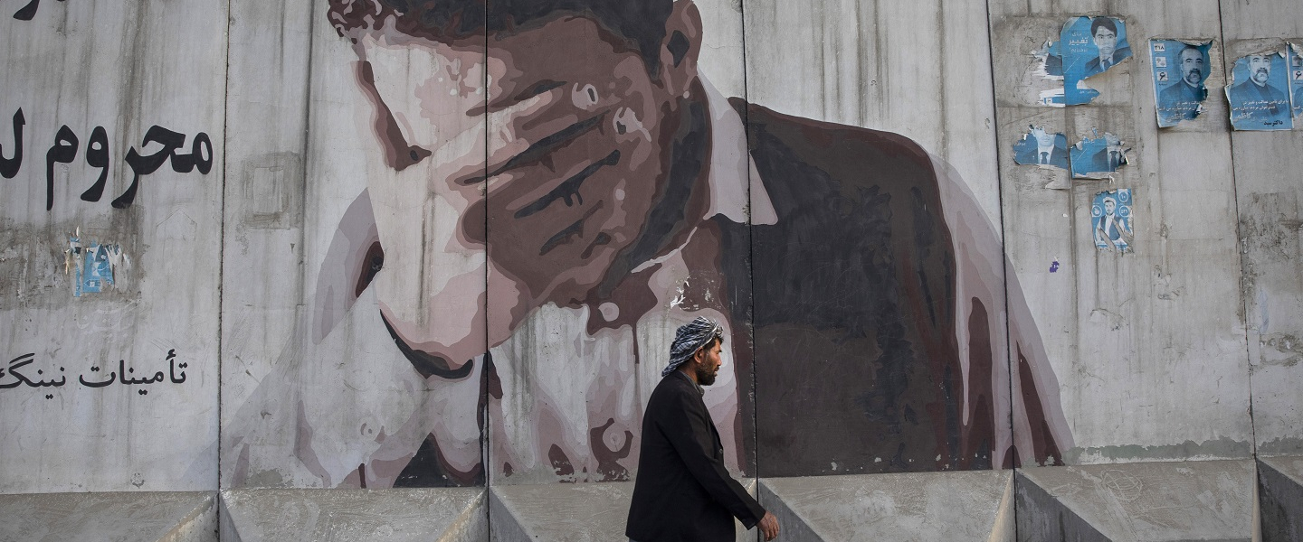 A man walks by a mural painted on a blast wall on September 29, 2019 in Kabul, Afghanistan. 