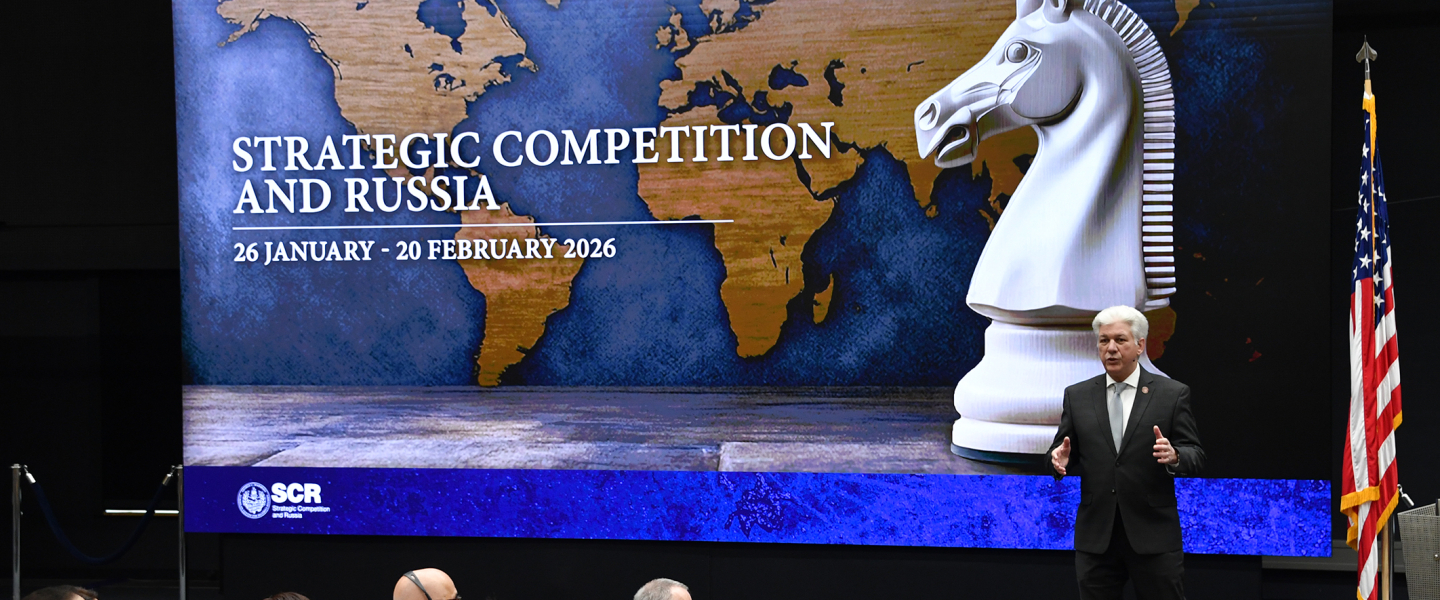 Man presents to crowd in plenary.